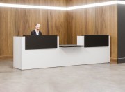 Banque d'accueil avec module PMR. Façade blanche et parements noirs