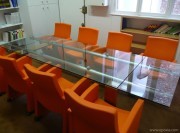 Table extensible en verre, collection Stilt avec fauteuils orange