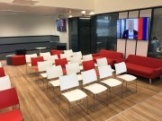 Salle de réunion avec estrade sur mesure et chaises empilables Curvy
